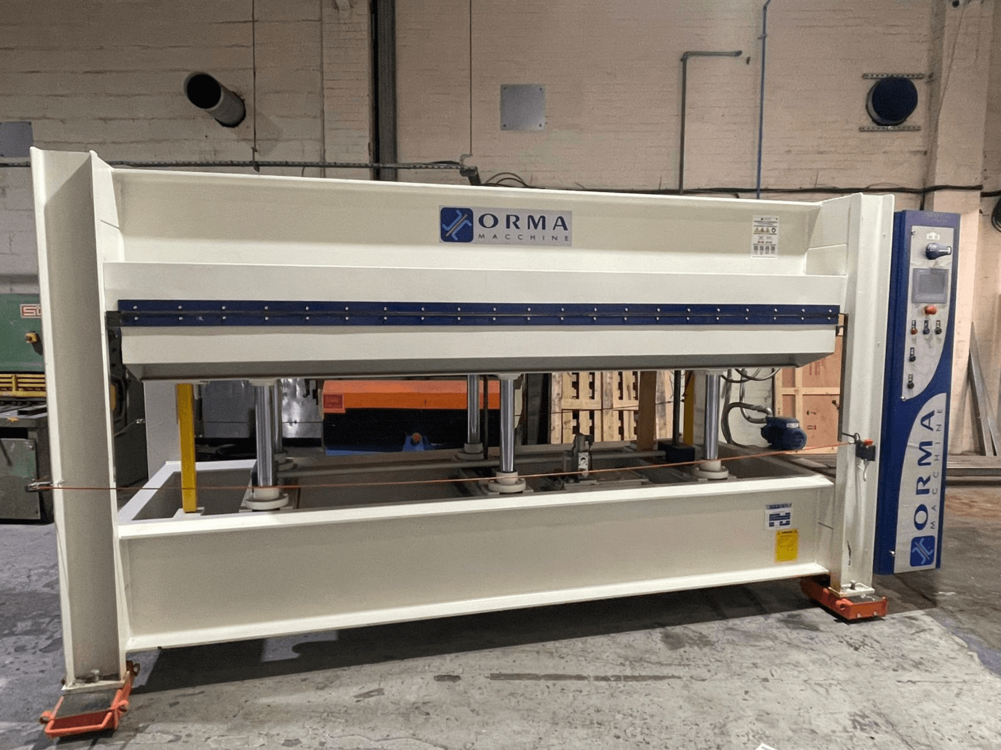 Hydraulický lis Orma Macchine v čelním pohledu, se čtyřmi svislými podpěrami a ovládacím panelem na pravé straně.