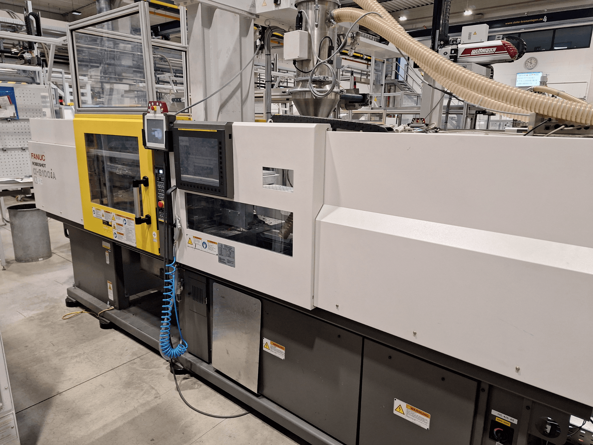 Vstřikovací stroj FANUC Roboshot α-S300iA, pohled zepředu, s ovládacím panelem a viditelnými průmyslovými komponenty.